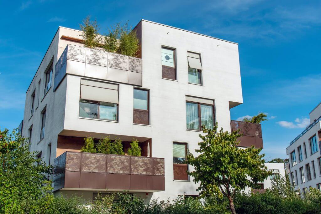 Modern white apartment house with metal balconies